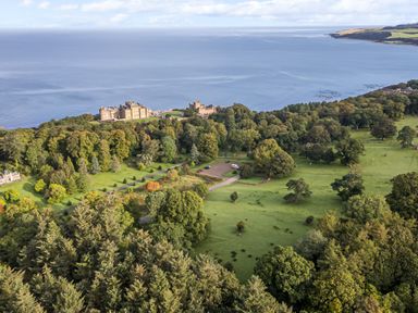 A large estate with a castle near the coastline surrounded by trees and grassy fields at Ardlochan Lodge - Culzean Castle in Maybole