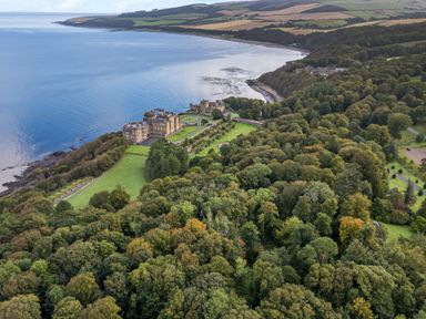A castle surrounded by trees and gardens near a coastline at Ardlochan Lodge - Culzean Castle in Maybole