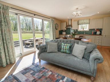 A living room with a sofa and kitchen area at Ardlochan Lodge - Culzean Castle in Maybole