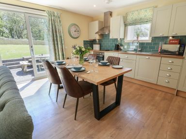A kitchen with dining table and chairs at Ardlochan Lodge - Culzean Castle in Maybole