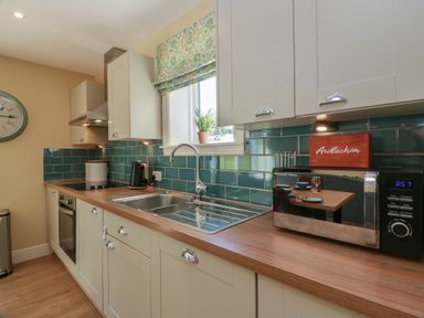 A kitchen with appliances and cabinets at Ardlochan Lodge - Culzean Castle Maybole
