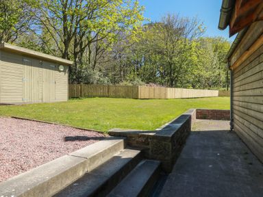 An outdoor area with a garden, steps, and a storage shed at Ardlochan Lodge - Culzean Castle, Maybole