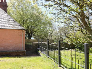 A garden with a house and a fence at Ardlochan Lodge - Culzean Castle Maybole