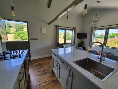 A kitchen with a gas stove and sink at Birch Banc Retreats - Bedw Llanidloes