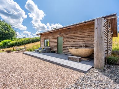 An outdoor view of a wooden building with a deck at Birch Banc Retreats - Bedw Llanidloes