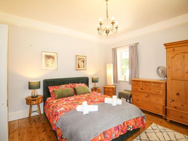A bedroom with a double bed and wooden furniture at Deer Leap House in Moreton