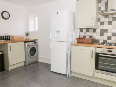 A kitchen with a washing machine fridge oven and countertop at Hazeldene in Sleights