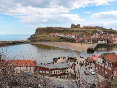 A coastal town with buildings beach and a hill with ruins at Hazeldene in Sleights