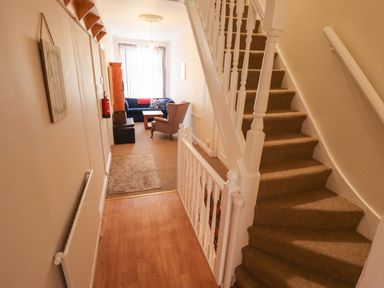 A hallway with a staircase and seating area at Maples in Hunstanton