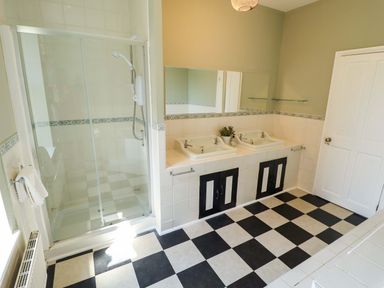 A bathroom with sinks and a shower at Maples in Hunstanton
