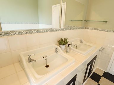 A bathroom with two sinks and a mirror at Maples in Hunstanton