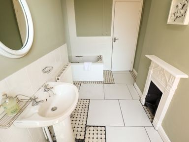 A bathroom with a bathtub and sink at Maples in Hunstanton