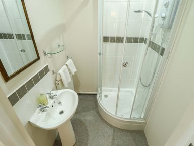 A bathroom featuring a shower, sink, and mirror at Maples in Hunstanton