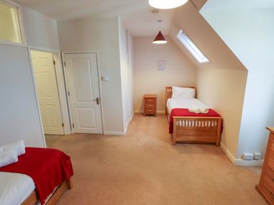 A bedroom with two beds and a nightstand at Maples in Hunstanton