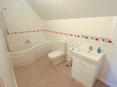 A bathroom with a bathtub, toilet, and sink at Maples, Hunstanton