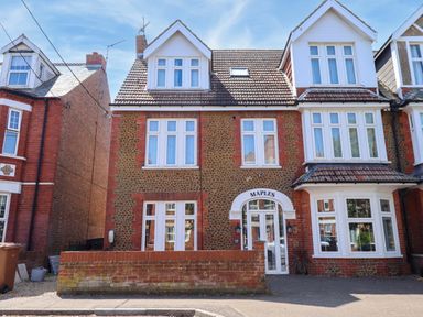 A house with multiple windows and a door at Maples in Hunstanton