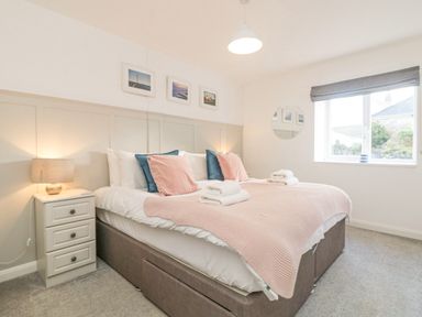 A bedroom with a double bed and bedside table with a lamp at The Old Post Office in Porthleven