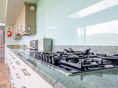 A kitchen with a gas stovetop toaster bread container and beige cabinets at Silverholme Graythwaite near Hawkshead