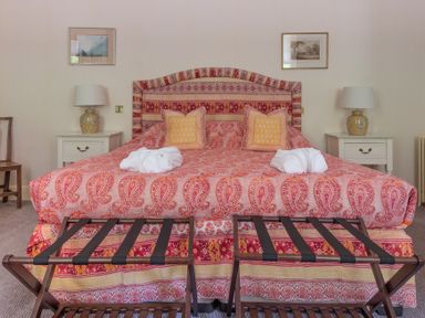 A bedroom with a patterned bedspread on a double bed with two bedside tables and lamps at Silverholme Graythwaite near Hawkshead