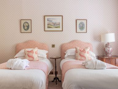 A bedroom with two single beds with pink patterned headboards and bedding at Silverholme Graythwaite near Hawkshead
