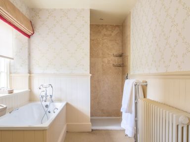 A bathroom with a bathtub and a walk-in shower at Silverholme in Graythwaite near Hawkshead