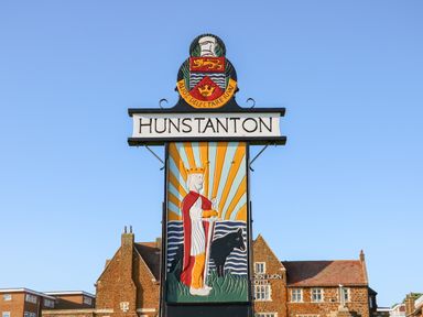 A sign with a figure of a king and a dog and the word Hunstanton with buildings in the background at Troon Cottage in Hunstanton
