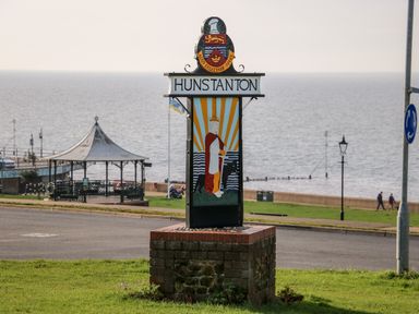 A town sign with a royal figure and sea in the background at Hunstanton