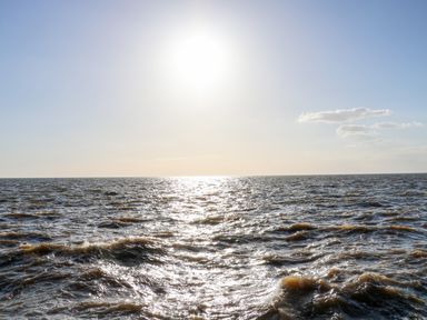 A view of the ocean with waves under a clear sky with the sun shining at Troon Cottage in Hunstanton