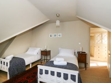 A bedroom with two single beds bedside tables and lamps at Troon Cottage Hunstanton