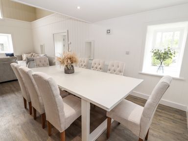 A dining room with a rectangular table and eight upholstered chairs at Sgubor in Valley
