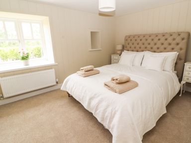 A bedroom with a double bed and towels on the bed at Sgubor in Valley