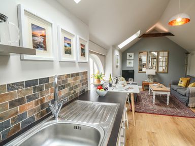 A kitchen sink with a countertop leading to a dining table and living area at Little Brook in Nottington near Weymouth