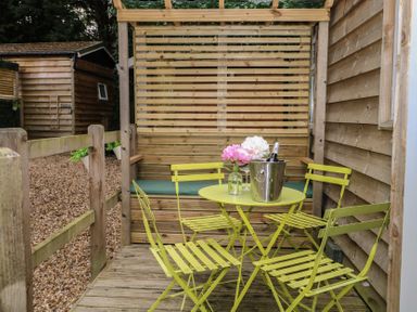An outdoor seating area with a table and chairs at Orchard Lodge in Bolney