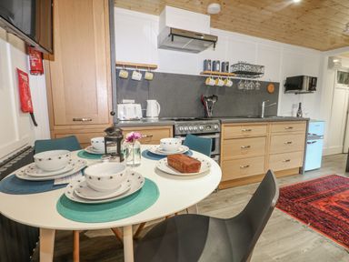A kitchen with a dining table set for meals at Harvest Lodge Wineham near Bolney