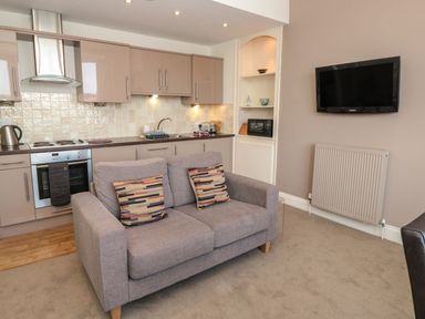 A kitchen with cabinets couch and a wall mounted tv at 4 Dartview in Dartmouth