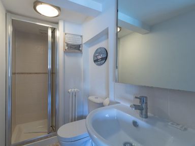 A bathroom with a shower cubicle toilet and sink at Harbourside Cottage in Brewers Quay Harbour