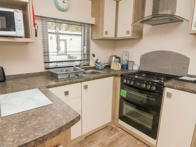 A kitchen with a stove microwave sink and countertop at 12A Borwick Lakes in South Lakeland Leisure Village