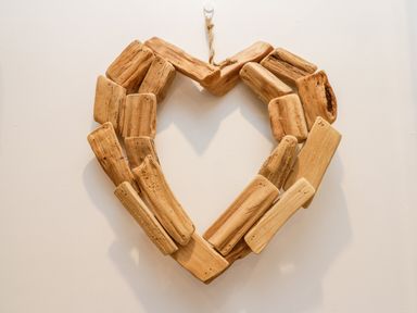 A heart-shaped decoration made of wooden pieces hanging on a white wall at The Lodge in Stainsacre near Whitby