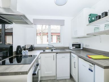 A kitchen with a stove oven dishwasher microwave sink and cabinets at Miles Retreat in Hayle