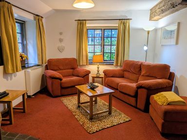 A living room with sofas and a coffee table at The Roundhouse in Warbstow