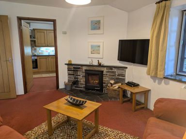 A living room with a fireplace and television at The Roundhouse in Warbstow