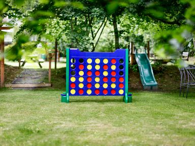 A large connect four game on grass with a green slide and wooden picnic bench in the background at Ash Cottage in Warbstow