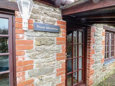 Exterior view of a stone and brick building with glass panel door and windows at Pond Meadow Warbstow