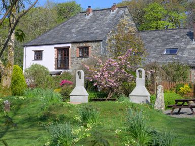 A garden with a house and stone features at Pond Meadow in Warbstow