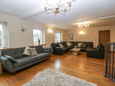 A living room with two sofas a coffee table and a rug at About Time Cottage in Parkend