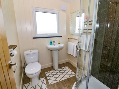 A bathroom with a toilet sink mirror and shower at Cotswold View 2 in Honeybourne