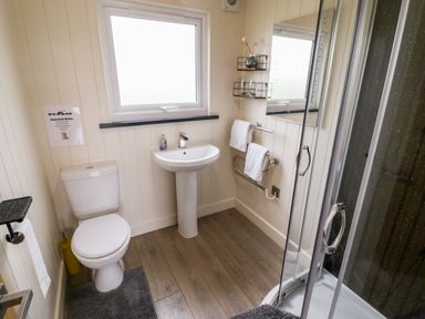 A bathroom with a toilet sink shower and towel racks at Cotswold View 4 in Bretforton near Evesham