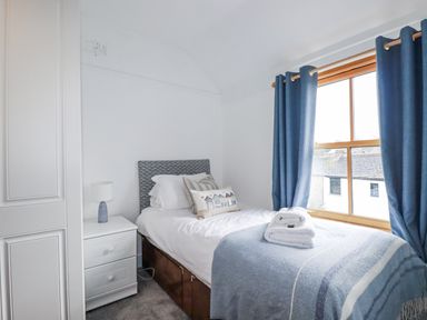 A bedroom with a single bed and window at Tresawle in Crantock