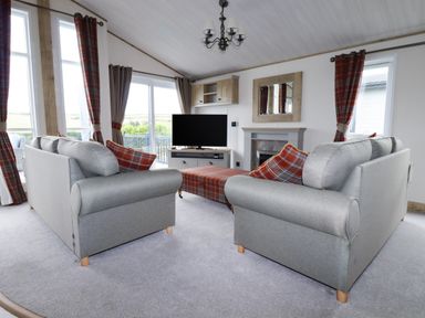 A living room with two sofas and a television at Beachcliff in Porth