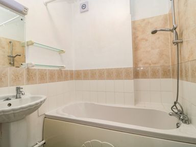 A bathroom with a bathtub shower combination and a pedestal sink at Bay Tree House in Seaton Devon
